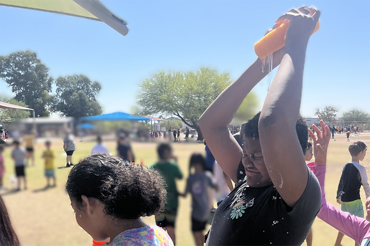 A boy pours a wet sponge over his head