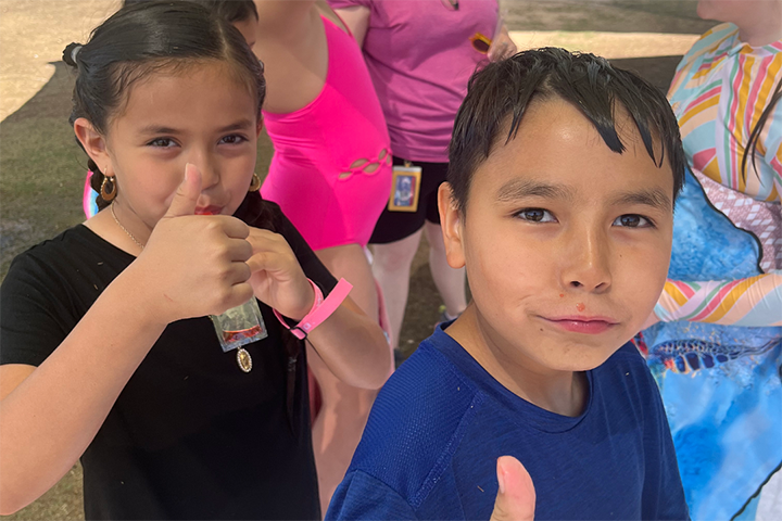 A girl and boy give a thumbs up as they enjoy their Otter Pops