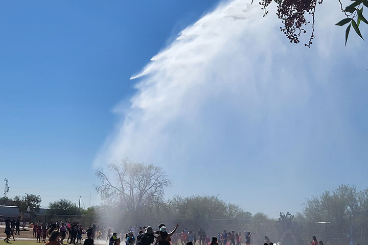 A fire truck sprays students with a huge blast of water