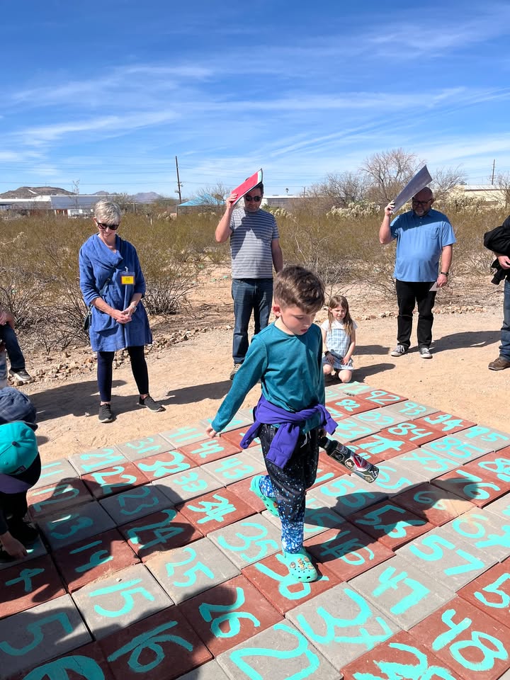 A little boy steps on tiles with numbers on them