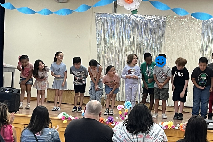 Students stand on stage