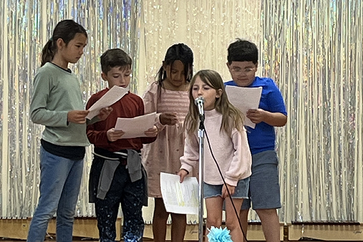 Students act out a story on stage