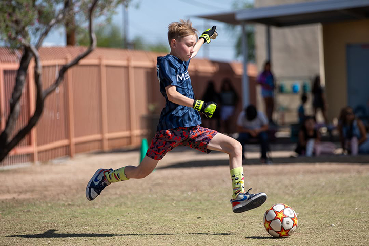 A boy kicks the soccer ball