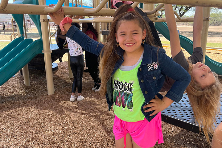 A girl shows off her 80s outfit on the playground