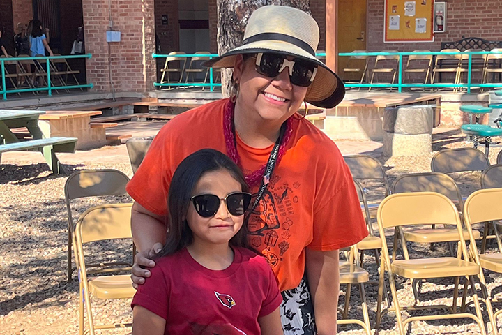 A girl and her teacher show off their sunglasses