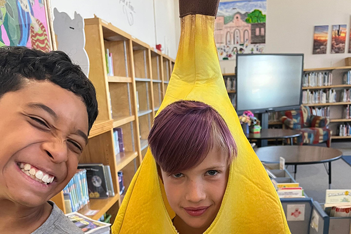 A boy dressed as a banana smiles with his friend