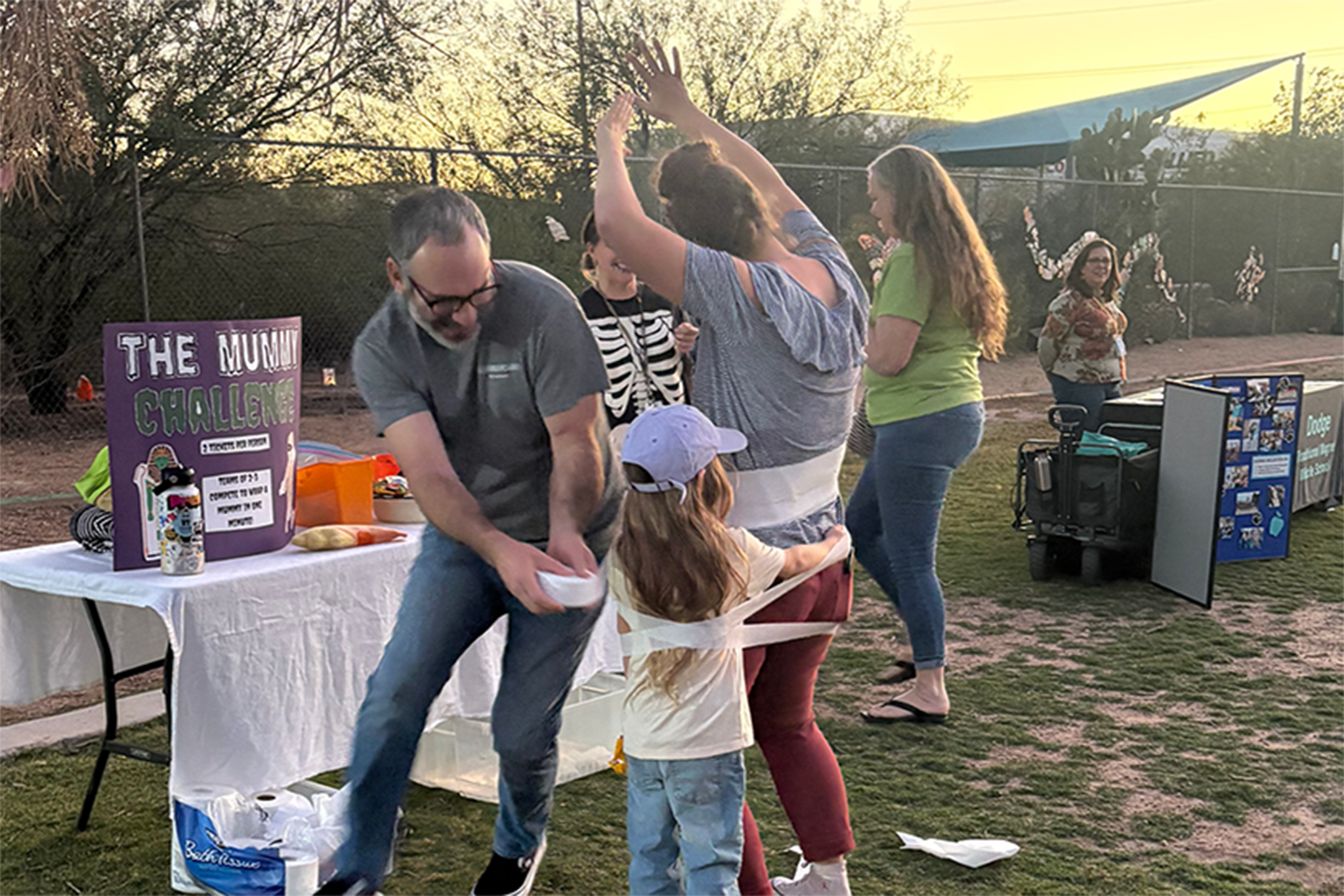 A little girl and a woman get wrapped in toilet paper