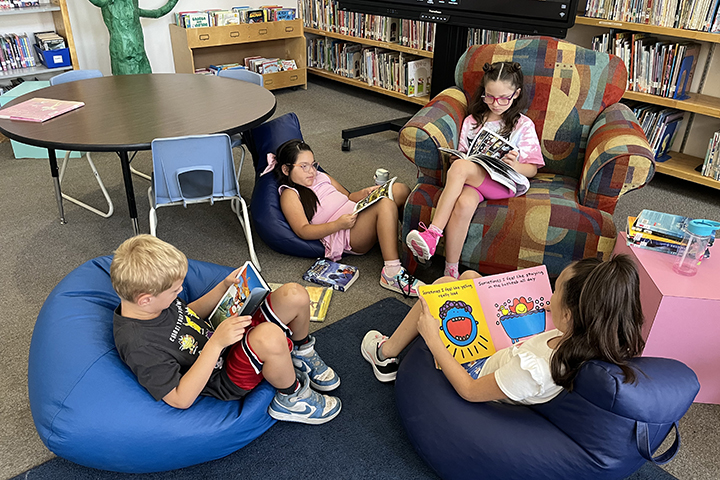 Students read books on bean bag chairs