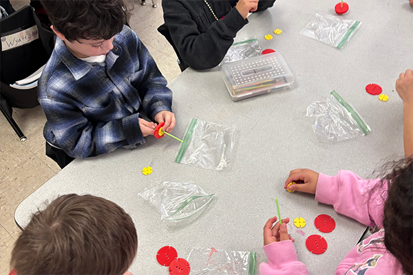 Students build spinning tops with straws and paper