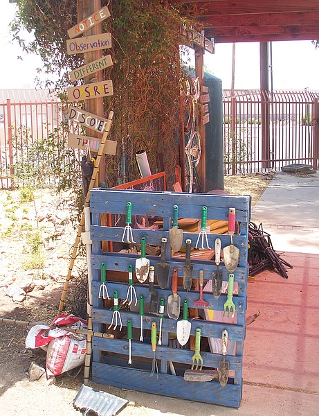 A wooden pallette holding gardening tools