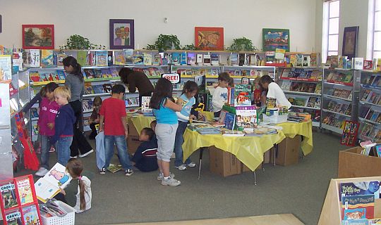 Children viewing scholastic book fair books to purchase