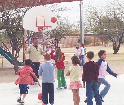 Children playing basketball on a basket ball court