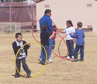 Kids playing with hula hoops on the playground